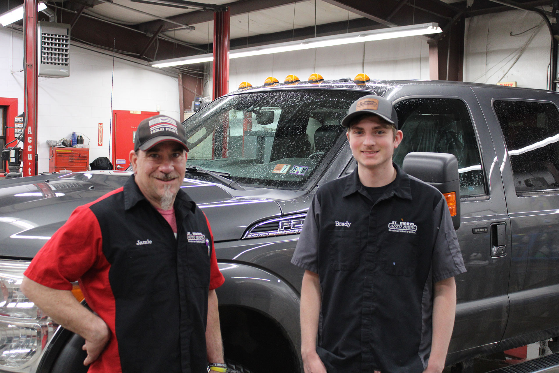 A photo of two of St Mary's Auto Body Employees in front of a truck | St Marys Auto Body